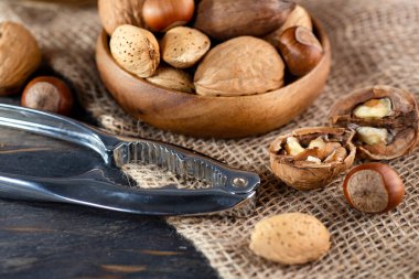 Çelik fındıkkıran ve fındık, ahşap masada, yakın plan..