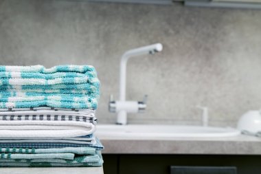 Mutfak havluları mutfak masasının üzerine istiflenmiş lavabo ve musluğun yanına. Metin için boşluk.