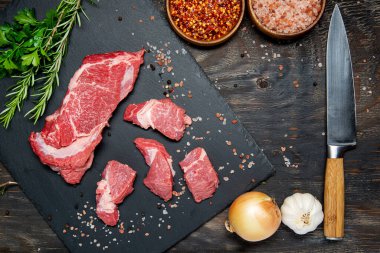 Organik çiğ et, sığır eti ya da kuzu eti koyu bir taş ya da beton arka planda. Kopyalama alanı olan üst görünüm.