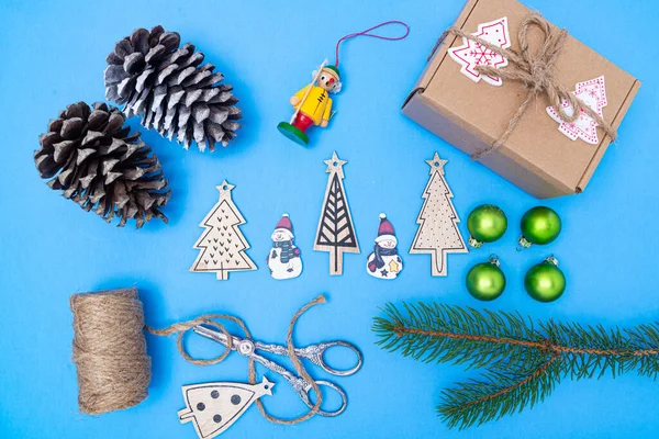 新年玩具 冷杉树枝和蓝色背景礼品盒的圣诞构图 从上面看 — 图库照片
