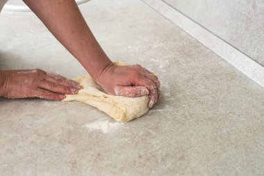 Kadınlar modern mutfak masasında hamur yoğurur.