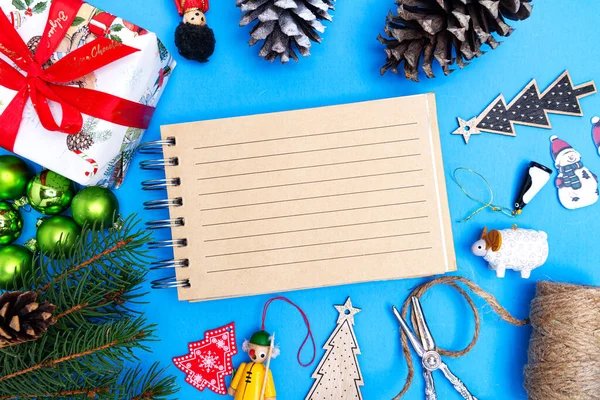 圣诞作文由玩具 冷杉枝 礼品盒和笔记本组成 并留有文字空间 在蓝色背景上 从上面看 — 图库照片