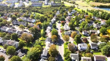 Washington yakınlarındaki düşük katlı tek aile evleri. Bir kuşun gözünden güneşli sonbahar manzarası. Mahalle yolları boyunca renkli ağaçlar. Virginia 'da Leesburg.