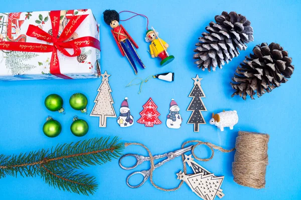 Kerstcompositie Van Nieuwjaarsspeelgoed Dennentakken Een Geschenkdoos Een Blauwe Achtergrond Uitzicht — Stockfoto