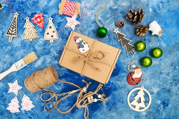 圣诞作文 圣诞装饰品 云杉树枝和球果 蓝色背景的礼品盒从上面看 — 图库照片
