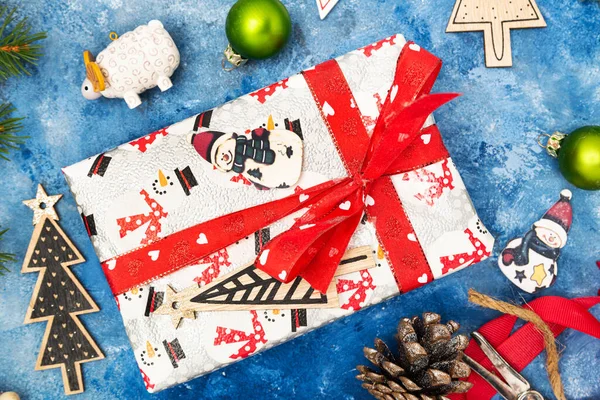 圣诞作文 圣诞装饰品 云杉树枝和球果 蓝色背景的礼品盒从上面看 — 图库照片