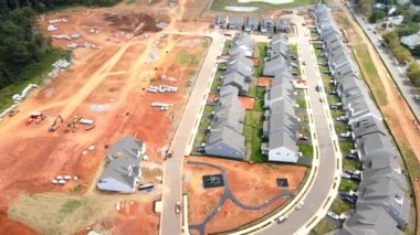 Yeni evleri ve yeni inşaatı olan bir inşaat alanı. Kırmızı kil ve iletişim. Ekipman ve borular. Yukarıdan görüntüle.