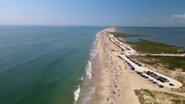 Chincoteague Adası Virginia sahilinin en alt manzarası. Atlantik Okyanusu kıyısındaki plajda araba park ediyor. Sahil boyunca sahil insanları ve çadırlar, vahşi yaşam sığınağı ve turizm beldesi.