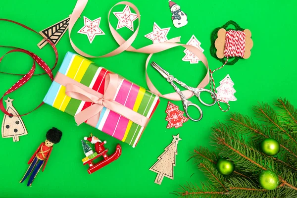 圣诞节礼物的概念 带彩带的礼品盒 圣诞装饰品和绿色背景的星星的俯瞰照片 — 图库照片