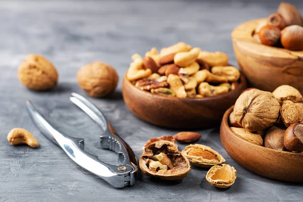 Diverse Noten Een Houten Kom Een Grijze Tafel Een Close — Stockfoto