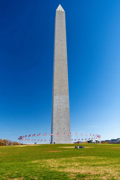 ワシントンD の雲一つない青空にアメリカ国旗に囲まれたジョージ ワシントン記念館 — ストック写真
