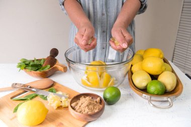 Mutfaktaki kadın limonata yapmak için limon suyu sıkıyor..