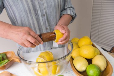 Mutfaktaki kadın limonata yapmak için limon suyu sıkıyor..