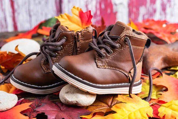 children\'s autumn shoes on bright autumn leaves. The concept of children\'s clothing for winter and autumn. Space for text.