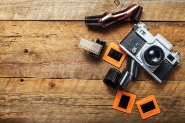 Eski model kamera ve kaydırak çerçevelerin ahşap kahverengi arka planda üst görünümü.