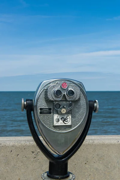 Coin-operated binoculars close-up mounted on the coast of the Atlantic Ocean. Space for text.