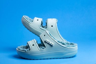 Mavi, parlak plaj ayakkabıları mavi arka planda timsahlar. Tatil için yaz plajı ayakkabıları.