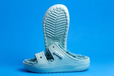 Timsah yürüyüş ayakkabıları, köpük tıkanma ayakkabıları mavi arka planda..