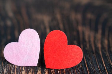 two red hearts on textured dark wooden table Love, valentine's day concept. Space text