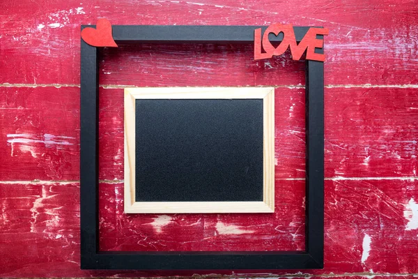 photo Frame, heart and word LOVE for Valentine\'s Day on a red wooden table. Top view with copy space