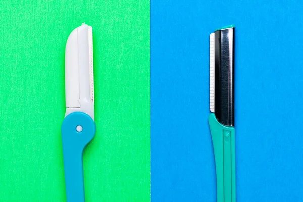 disposable razor blade on green and blue background. Single use razors blade. Disposable shaving razors. Body care.