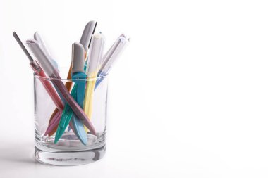 multi-colored women's shaving razors in glass isolated on white background. Space for text.