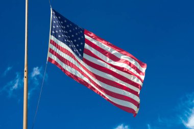 Amerikan bayrağı mavi gökyüzü karşı rüzgarda sallayarak.