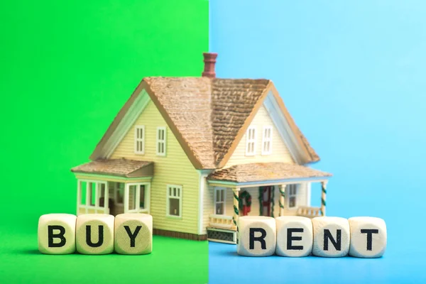 Buy or rent a house. Concept from a house model and wooden cubes.