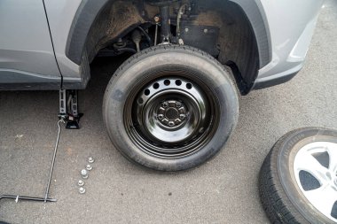  Yolda acil onarımlar var. Patlak bir tekerleği, yolda geçici bir tekerlekle değiştirmek.