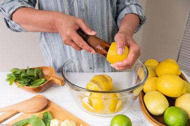 Mutfaktaki kadın limonata yapmak için limon suyu sıkıyor..