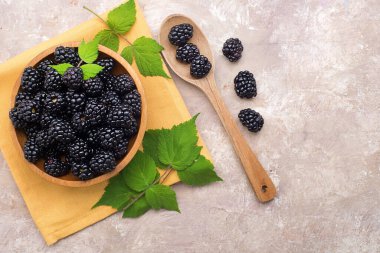 Tahta tabak ve kaşıkla taze böğürtlen. Yukarıdan bak. Metin için boşluk.