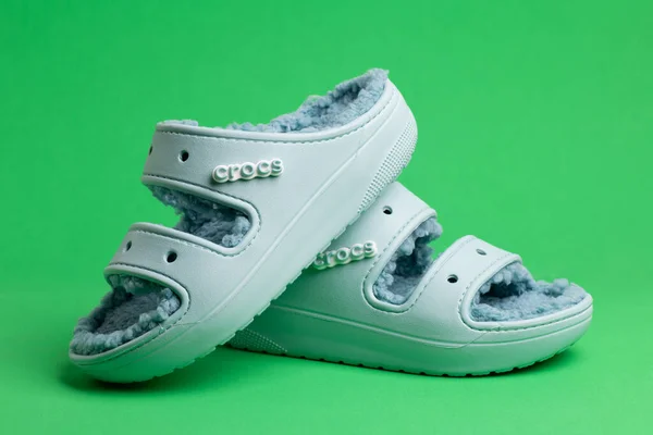 Yeşil Arka Planda Sahte Kürklü Mavi Crocs Sandaletleri Yakın Plan — Stok fotoğraf