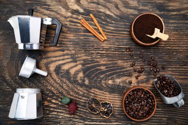 geyser coffee maker, coffee beans and ground coffee on a dark wooden table. View from above.