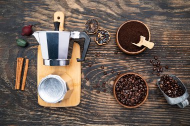 geyser coffee maker, coffee beans and ground coffee on a dark wooden table. View from above.