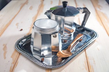 geyser coffee maker and coffee beans on a white wooden table.