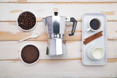 Cup of coffee, geyser coffee maker and coffee beans on ,white wooden table. top view.