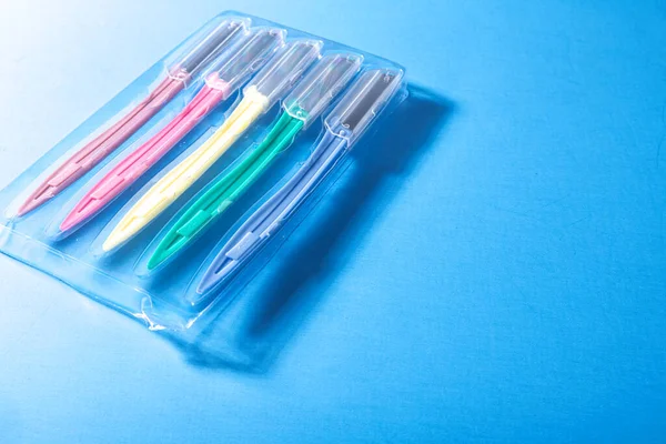 Conjunto Maquinillas Afeitar Multicolor Una Caja Plástico Sobre Fondo Azul — Foto de Stock