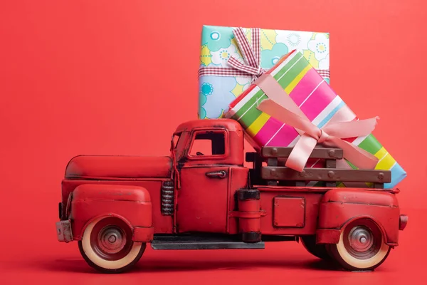 红色背景的老式卡车后座装有彩带的礼品盒 — 图库照片
