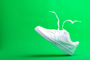 Beyaz ayakkabılı Nike yeşil arka planda. Şık, şık, deri spor ayakkabılar. Metin için boşluk