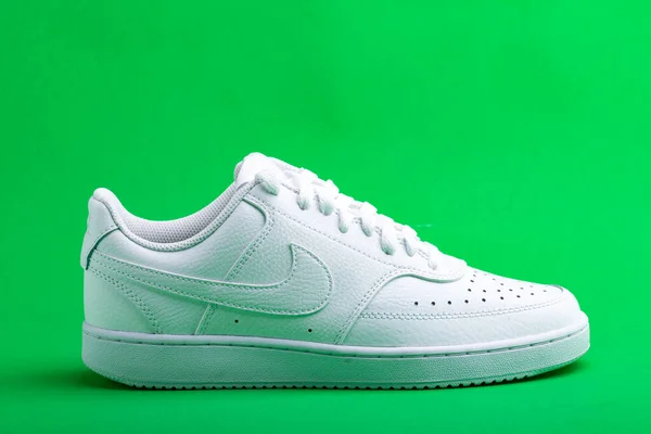 白色运动鞋耐克绿色背景 时尚时髦的皮鞋休闲鞋 — 图库照片