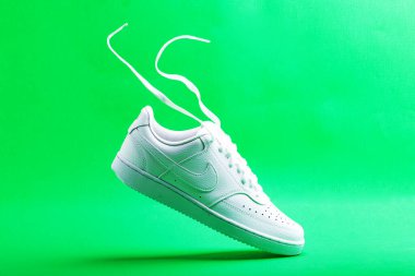 Beyaz ayakkabılı Nike yeşil arka planda. Şık, şık, deri spor ayakkabılar..