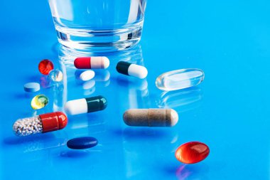 Tabletler ve masanın üzerinde bir bardak su. Su içmek ve ilaç almak - hastalık sırasında vücudunuzu güçlendirir