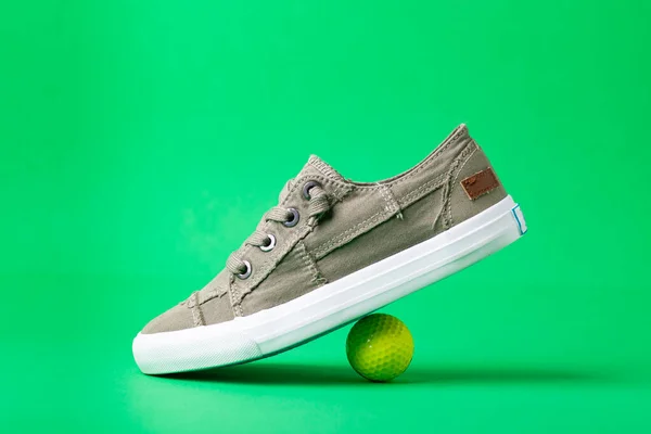 Spor Ayakkabıları Yeşil Arka Planda Bir Golf Topu Mesaj Için — Stok fotoğraf