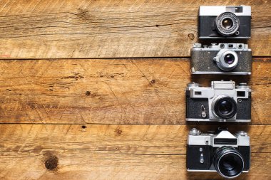 Eski fotoğraf makineleri ahşap bir masanın üzerinde. Yukarıdan bak. Eski tarz. Metin için boşluk.