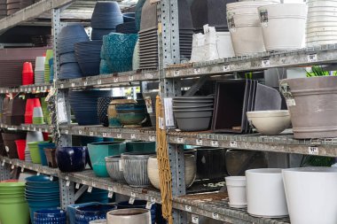 Bir bahçe mağazasının raflarında çeşitli boş saksılar var..