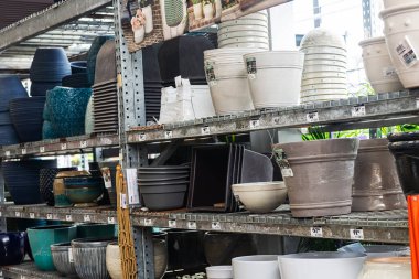 Bir bahçe mağazasının raflarında çeşitli boş saksılar var..