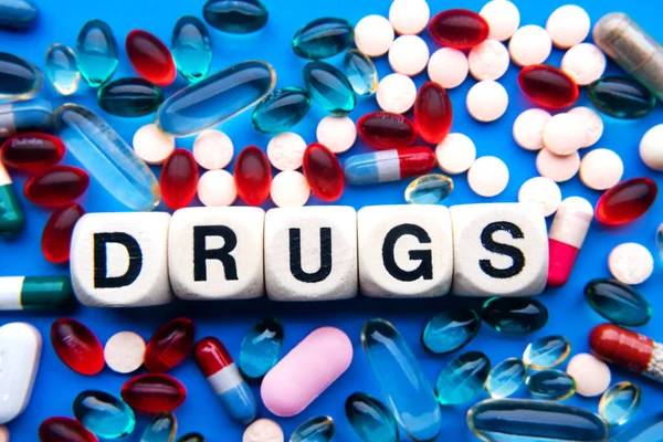 Nápis Drugs Dřevěných Kostkách Modrém Pozadí Různých Pilulek — Stock fotografie