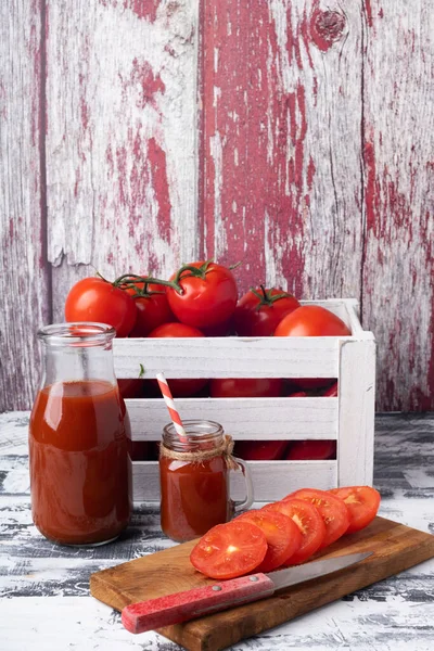 木の箱にトマトを入れ まな板にナイフでトマトをスライスしました ガラスのボウルに新鮮なトマトジュース テキストの場所 — ストック写真