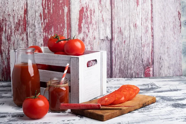 白いテーブルの上に木の箱に新鮮なトマト トマトジュース付きボトルとガラス — ストック写真