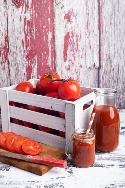 木の箱にトマトを入れ まな板にナイフでトマトをスライスしました ガラスのボウルに新鮮なトマトジュース テキストの場所 — ストック写真